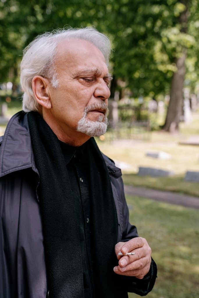 An elderly bearded man smoking